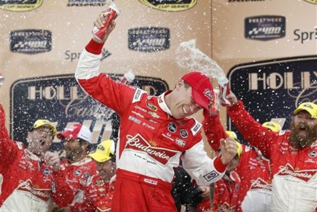 Driver Kevin Harvick celebrates in victory lane after winning the Hollywood Casino 400 NASCAR Sprint Cup series auto race at Kansas Speedway in Kansas City, Kan., Sunday, Oct. 6, 2013. (AP Photo/Colin E. Braley)