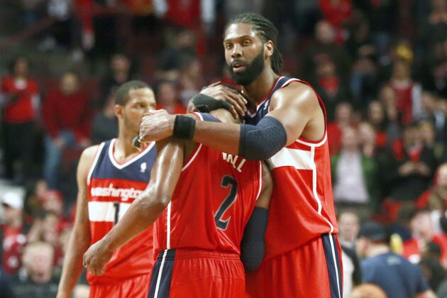 Washington Wizards forward Nene Hilario, right, hugs guard John Wall in the closing seconds of the second half of Game 5 in an opening-round NBA basketball playoff series against the Chicago Bulls, Tuesday, April 29, 2014, in Chicago. The Wizards eliminated the Bulls winning 75-69. (AP Photo/Charles Rex Arbogast)