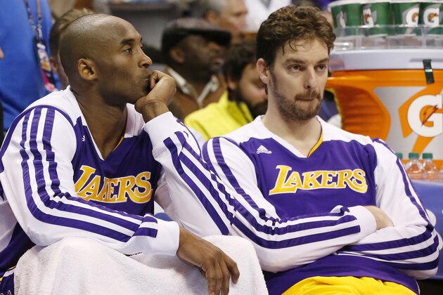 Los Angeles Lakers guard Kobe Bryant, left, and center Paul Gasol, right, watch from the bench in the fourth quarter of an NBA basketball game against the Oklahoma City Thunder in Oklahoma City, Friday, Dec. 13, 2013. Oklahoma City won 122-97. (AP Photo/Sue Ogrocki)