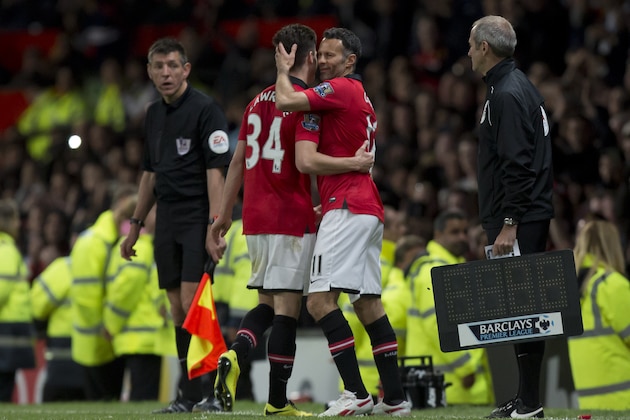 Manchester United's interim manager Ryan Giggs, right, embraces teammate Tom Lawrence as he takes to the pitch as a substitute during his team's English Premier League soccer match against Hull at Old Trafford Stadium, Manchester, England, Tuesday May 6, 2014. (AP Photo/Jon Super)