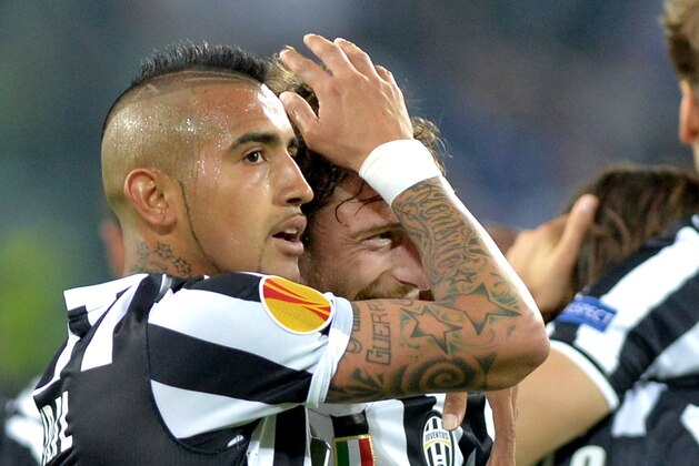 Juventus midfielder Claudio Marchisio, center, celebrates after scoring with teammate Arturo Vidal during the Europa League quarterfinal soccer match between Juventus and Olympic Lyon at the Juventus stadium, in Turin, Italy, Thursday, April 10, 2014. (AP Photo/ Massimo Pinca)
