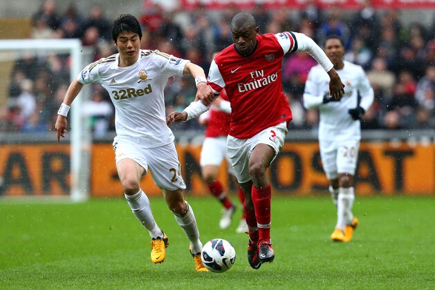 SWANSEA, WALES - MARCH 16:   Abou Diaby of Arsenal battles with Ki Sung-Yueng of Swansea City during the Barclays Premier League match between Swansea City and Arsenal at Liberty Stadium on March 16, 2013 in Swansea, Wales.  (Photo by Jan Kruger/Getty Images)