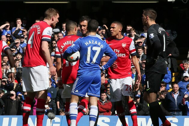 Arsenal's Kieran Gibbs, second right,along with teammate  Alex Oxlade-Chamberlain, second left, question the referee Andre Marriner, in grey, after being shown a red card during their English Premier League soccer match between Chelsea and Arsenal at Stamford Bridge stadium in London Saturday, March  22  2014. Although Alex Oxlade-Chamberlain blatantly handled to keep out Eden Hazard's shot, it was Kieran Gibbs who was dismissed despite his teammate's protests. Hazard scored Chelsea's third from the resulting penalty.(AP Photo/Alastair Grant)