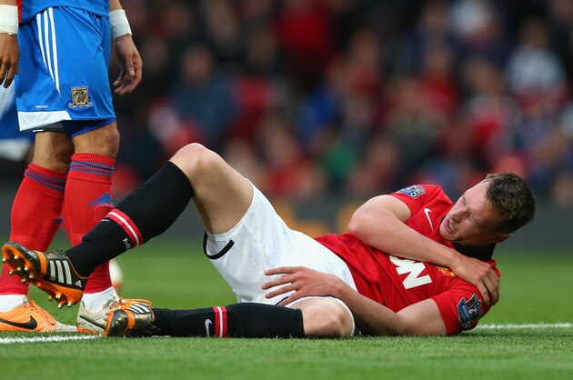 MANCHESTER, ENGLAND - MAY 06:  Phil Jones of Manchester United holds his shoulder after sustaining an injury during the Barclays Premier League match between Manchester United and Hull City at Old Trafford on May 6, 2014 in Manchester, England.  (Photo by Alex Livesey/Getty Images)