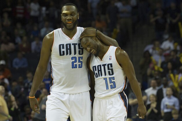 Mar 31, 2014; Charlotte, NC, USA; Charlotte Bobcats guard Kemba Walker (15) celebrates with center Al Jefferson (25) during the second half against the Washington Wizards at Time Warner Cable Arena. Bobcats defeated the Wizards 100-94. Mandatory Credit: Jeremy Brevard-USA TODAY Sports