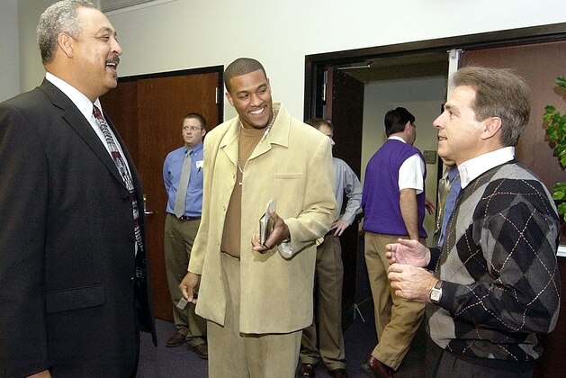 Louisiana State wide receiver Michael Clayton, center, shares a laugh with his father, Milton Clayton, left, and LSU coach Nick Saban before the start of a news conference in  Baton Rouge, La. Sunday afternoon, Jan. 11, 2004. Clayton announced that he would forego his senior year with the Tigers and enter the NFL draft. (AP Photo/Bill Haber