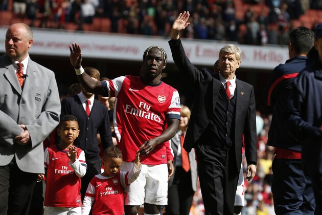 Arsenal's manager Arsene Wenger, center right, and Bacary Sagna, center left, wave to the supporters as the team parade around the stadium in their last home match of the season, after their English Premier League soccer match against West Bromwich Albion at Emirates Stadium in London, Sunday, May 4, 2014. (AP Photo/Sang Tan)