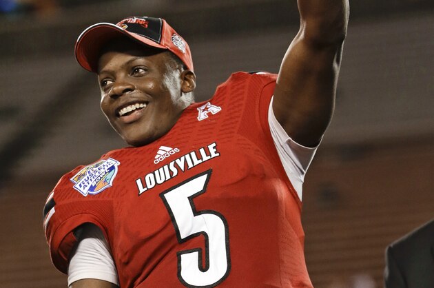 Louisville quarterback Teddy Bridgewater (5) holds up the MVP trophy after Louisville defeated Miami 36-9 in the Russell Athletic Bowl NCAA college football game in Orlando, Fla., Saturday, Dec. 28, 2013.(AP Photo/John Raoux)