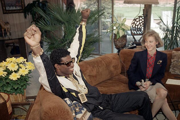 Florida State's Deion Sanders, left, reacts as he sits with television reporter Andrea Kremer, at his agent's suburban home in Winnetka, Ill., on April 23, 1989.   Sanders was selected by the Atlanta Falcons in the first round of  the NFL draft.  Sanders, a two-time All-American cornerback at FSU, was the fifth player selected in the first round.     (AP Photo)