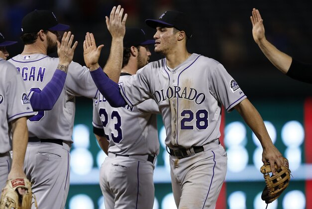 May 7, 2014; Arlington, TX, USA; Colorado Rockies third baseman Nolan Arenado (28) congratulates teammates following their 9-2 win over the Texas Rangers at Globe Life Park in Arlington. The Rockies won 9-2. Mandatory Credit: Jim Cowsert-USA TODAY Sports