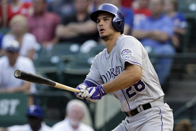 Colorado Rockies' Nolan Arenado watches the flight of his two-run double off a pitch from Texas Rangers' Colby Lewis in the first inning of a baseball game, Wednesday, May 7, 2014, in Arlington, Texas. The hit, that extended Arenado's hitting streak to 27 games, scored Troy Tulowitzki and Carlos Gonzalez. (AP Photo/Tony Gutierrez)