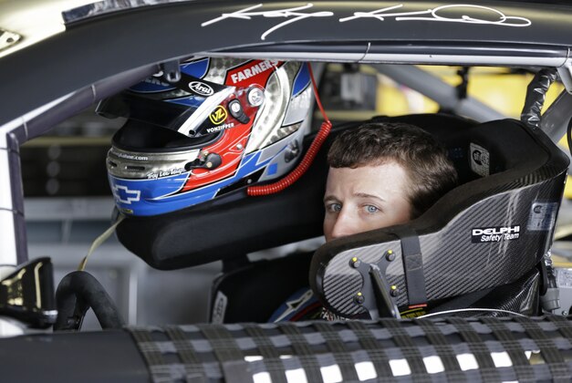 NASCAR driver Kasey Kahne waits in his garage while crew member make adjustments to his car during Sprint Cup auto racing testing at Daytona International Speedway in Daytona Beach, Fla., Friday, Jan. 10, 2014.(AP Photo/John Raoux)