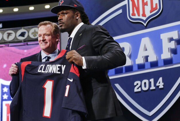 Jadeveon Clowney, defensive end de Carolina del Sur, sostiene un jersey de los Texans de Houston luego de ser la primera selección del draft de la NFL. A su lado el comisionado de la liga, Roger Goodell, el jueves 8 de mayo de 2014. (Foto AP/Craig Ruttle)