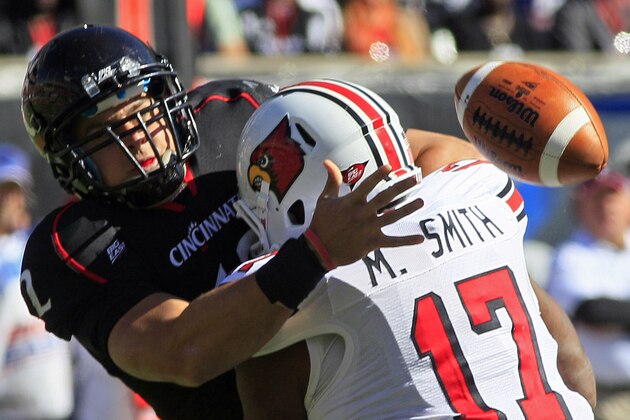 Cincinnati quarterback Zach Collaros fumbles the ball as he is sacked by Louisville defensive end Marcus Smith (17) during the first half of an NCAA college football game, Saturday, Oct. 15, 2011, in Cincinnati. Cincinnati recovered the fumble. (AP Photo/Al Behrman)