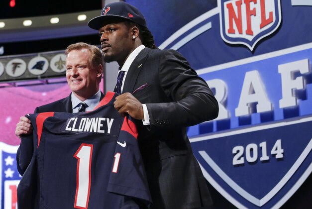 Jadeveon Clowney, defensive end de Carolina del Sur, sostiene un jersey de los Texans de Houston luego de ser la primera selección del draft de la NFL. A su lado el comisionado de la liga, Roger Goodell, el jueves 8 de mayo de 2014. (Foto AP/Craig Ruttle)