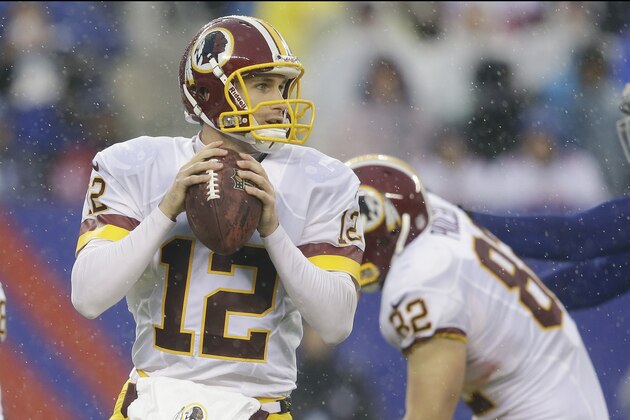 In the rain, Washington Redskins quarterback Kirk Cousins (12) looks to pass during the first half of an NFL football game against the New York Giants, Sunday, Dec. 29, 2013, in East Rutherford, N.J.  (AP Photo/Julio Cortez)