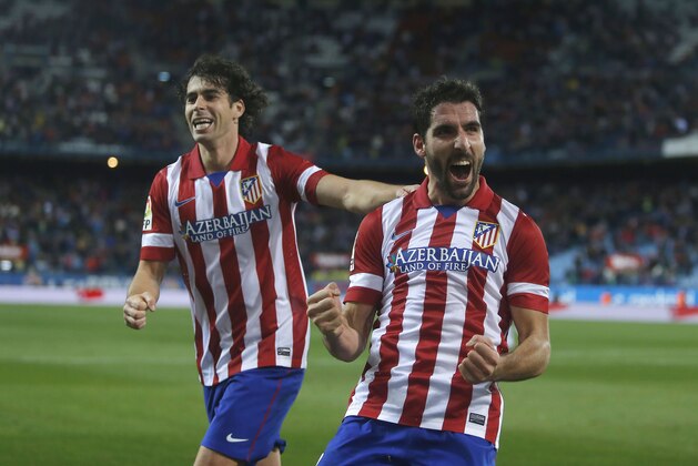 Atletico's Raul Garcia, centre, celebrates his goal with Tiago during a Spanish Copa del Rey soccer match between Atletico de Madrid and Valencia at the Vicente Calderon stadium in Madrid, Spain, Tuesday, Jan. 14, 2014. (AP Photo/Andres Kudacki)