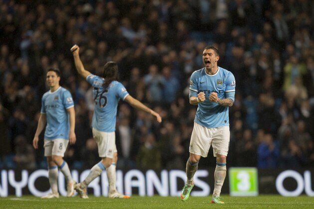 Manchester City's Aleksander Kolarov, right, celebrates after his team's 4-0 win against Aston Villa in their English Premier League soccer match at the Etihad Stadium, Manchester, England, Wednesday May 7, 2014. (AP Photo/Jon Super)