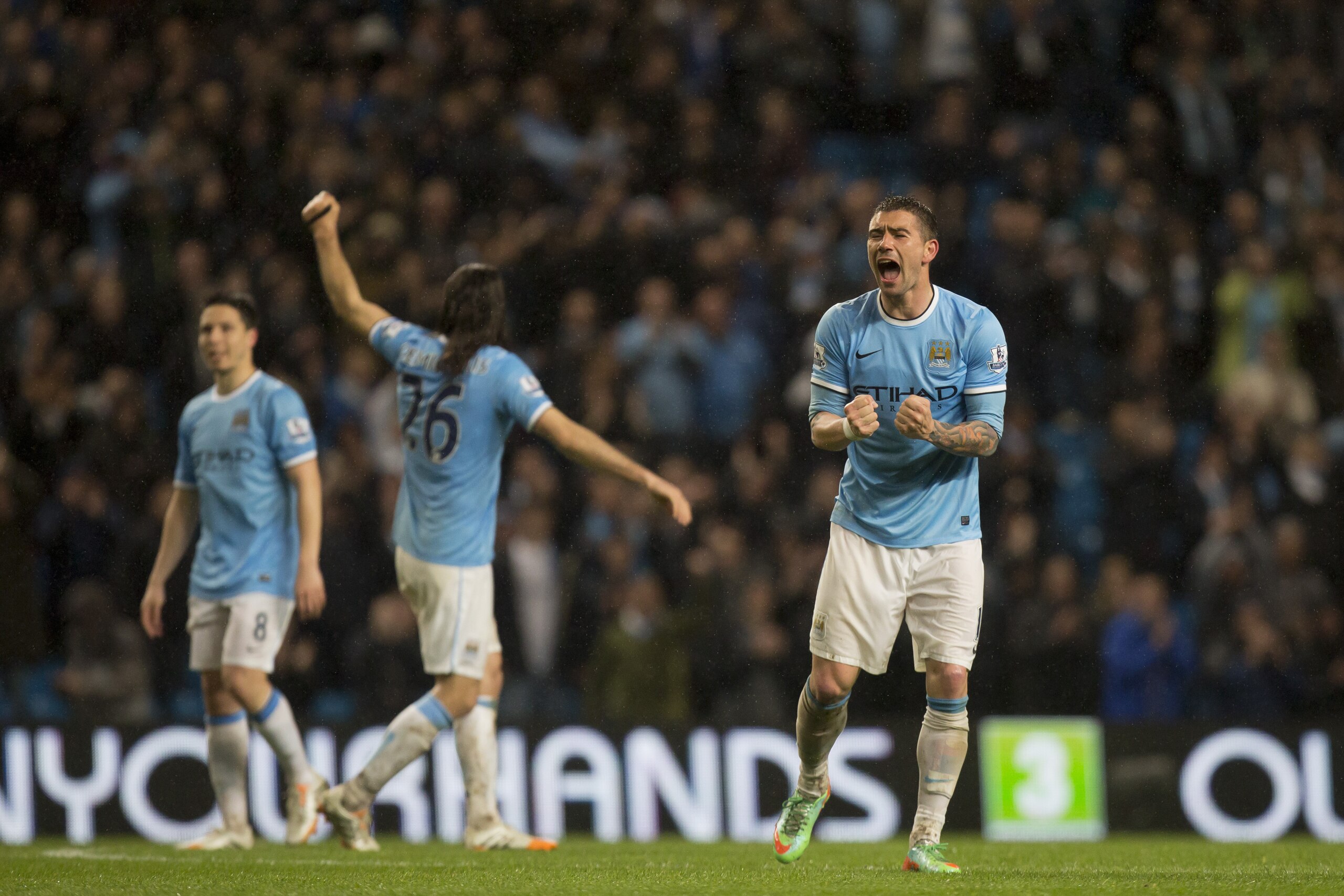 Manchester City's Aleksander Kolarov, right, celebrates after his team's 4-0 win against Aston Villa in their English Premier League soccer match at the Etihad Stadium, Manchester, England, Wednesday May 7, 2014. (AP Photo/Jon Super)