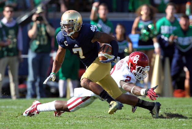Sep 28, 2013; South Bend, IN, USA; Notre Dame Fighting Irish wide receiver T.J. Jones (7) runs past Oklahoma Sooners defensive back Julian Wilson (2) at Notre Dame Stadium. Mandatory Credit: Brian Spurlock-USA TODAY Sports