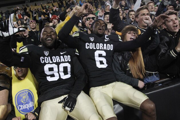 Colorado defensive lineman De'Jon Wilson, left, joins wide receiver Paul Richardson in singing the school song with fans after their 41-24 victory over California in an NCAA football game in Boulder, Colo., Saturday, Nov. 16, 2013. (AP Photo/David Zalubowski)