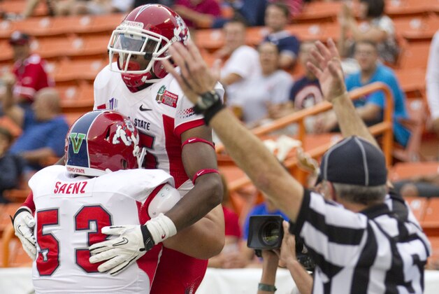 Fresno State offensive linesman Mike Saenz (53) picks up wide receiver Davante Adams (15) after Adams' touchdown reception in the third quarter against SMU in the Hawaii Bowl, an NCAA college football game Monday, Dec. 24, 2012, in Honolulu. (AP Photo/Eugene Tanner)