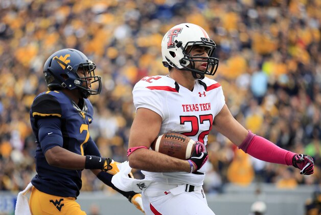 Texas tech's Jace Amaro (22) carries the ball in after a catch for a touchdown as West Virginia's Daryl Worley (7) chases during the first quarter of an NCAA college football game in Morgantown, W.Va., on Saturday, Oct. 19, 2013. (AP Photo/Chris Jackson)