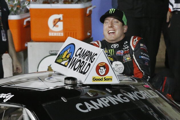 Kyle Busch slips as he climbs out of his car after winning the NASCAR Camping World Truck Series race at Kansas Speedway in Kansas City, Kan., Friday, May 9, 2014. (AP Photo/Orlin Wagner)