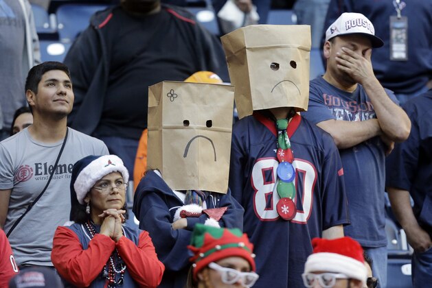 Houston Texans fans wear paper bags on their heads during the fourth quarter of an NFL football game against the Denver Broncos, Sunday, Dec. 22, 2013, in Houston. Denver won 37-13. (AP Photo/Patric Schneider)