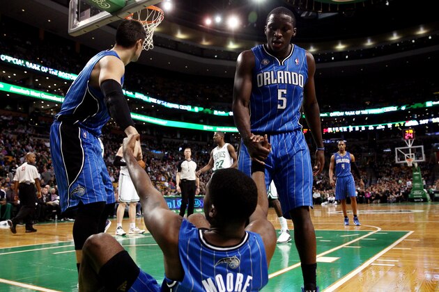 BOSTON, MA - NOVEMBER 11: E'Twaun Moore #55 is helped up by teammates Nikola Vucevic #9 and Victor Oladipo #5 of the Orlando Magic during a game against the Boston Celtics at the TD Garden on November 11, 2013 in Boston, Massachusetts. NOTE TO USER: User expressly acknowledges and agrees that, by downloading and/or using this photograph, user is consenting to the terms and conditions of the Getty Images License Agreement.  (Photo by Alex Trautwig/Getty Images)