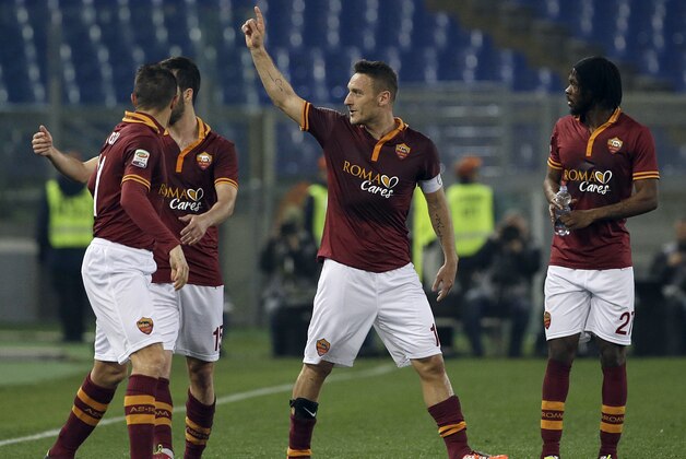 AS Roma's Francesco Totti, center, celebrates with teammates after scoring during a Serie A soccer match between AS Roma and Udinese in Rome's Olympic stadium, Monday, March 17, 2014. (AP Photo/Gregorio Borgia)
