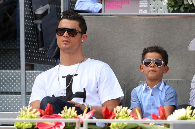MADRID, SPAIN - MAY 08:  Real Madrid footballer Cristiano Ronaldo and his son Cristiano Ronaldo Junior watch Rafael Nadal of Spain against Jarkko Nieminen of Finland in their third round match during day six of the Mutua Madrid Open tennis tournament at the Caja Magica on May 8, 2014 in Madrid, Spain.  (Photo by Clive Brunskill/Getty Images)
