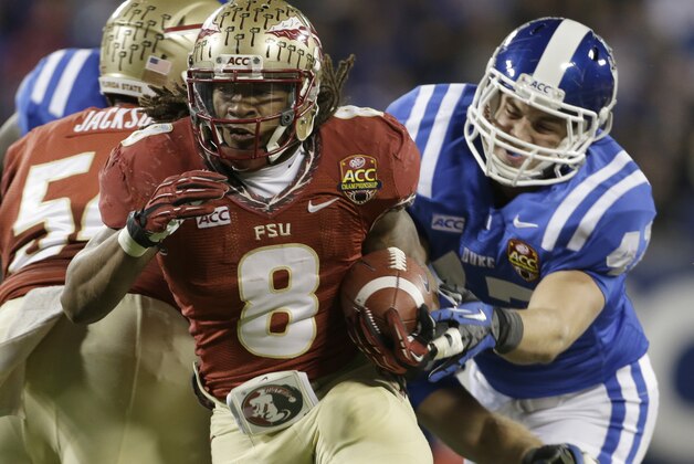 Florida State's Devonta Freeman (8) runs past Duke's David Helton (47) in the first half of the Atlantic Coast Conference Championship NCAA football game in Charlotte, N.C., Saturday, Dec. 7, 2013. (AP Photo/Bob Leverone)