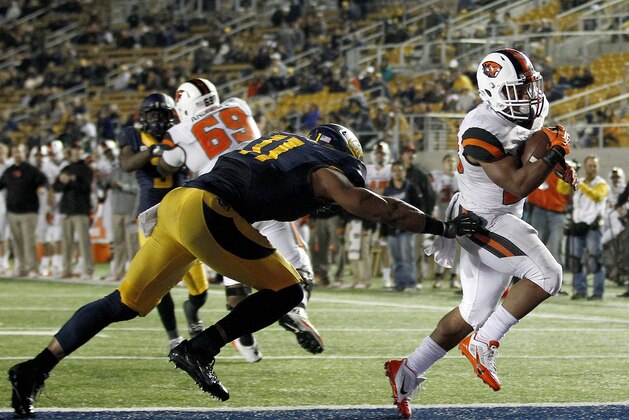 Oregon State running back Terron Ward (28) scores a touchdown past California linebacker Khairi Fortt (11) during the second half of an NCAA college football game in Berkeley, Calif., Saturday, Oct. 19, 2013. (AP Photo/Tony Avelar)