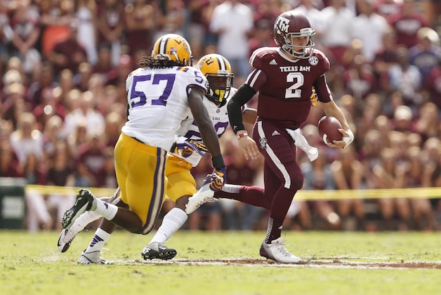 Oct 20, 2012; College Station, TX, USA; Texas A&M Aggies quarterback Johnny Manziel (2) scrambles from LSU Tigers linebacker Lamin Barrow (57) and cornerback Jalen Mills (28) during the first half at Kyle Field. Mandatory Credit: Thomas Campbell