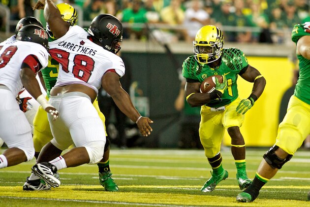 EUGENE, OR - SEPTEMBER 1: Kenjon Barner #24 of the Oregon Ducks rushes past Ryan Carrethers #98 of the Arkansas State Red Wolves in the second quarter on September 1, 2012 at Autzen Stadium in Eugene, Oregon.  (Photo by Craig Mitchelldyer/Getty Images)