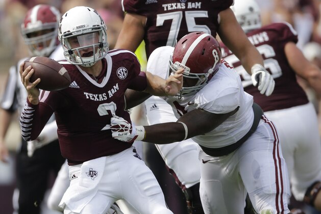Texas A&M quarterback Johnny Manziel (2) escapes from Alabama defensive lineman Jeoffrey Pagan (8) during the second quarter of an NCAA college football game Saturday, Sept. 14, 2013 in College Station, Texas. (AP Photo/David J. Phillip)