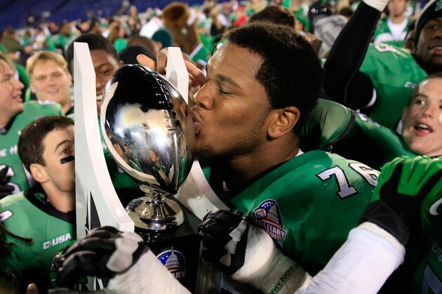ANNAPOLIS, MD - DECEMBER 27: Offensive linesman Garrett Scott #76 of the Marshall Thundering Herd kisses the trophy after defeating the Maryland Terrapins 31-20 to win the 2013 Military Bowl at Navy Marine Corps Memorial Stadium on December 27, 2013 in Annapolis, Maryland.  (Photo by Rob Carr/Getty Images)