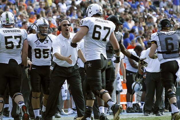 Nov 9, 2013; Gainesville, FL, USA; Vanderbilt Commodores head coach James Franklin celebrates with offensive linesman Wesley Johnson (67) after they scored a touchdown against the Florida Gators during the second half at Ben Hill Griffin Stadium. Vanderbilt Commodores defeated the Florida Gators 34-17. Mandatory Credit: Kim Klement-USA TODAY Sports