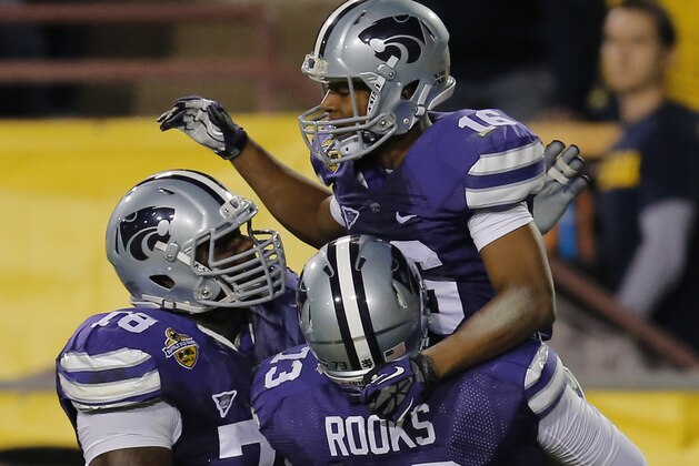 Kansas State wide receiver Tyler Lockett (16) celebrate his touchdown with teammates Tavon Rooks (73) and Cornelius Lucas (78) during the first half of the Buffalo Wild Wings Bowl NCAA college football game against Michigan, Saturday, Dec. 28, 2013, in Tempe, Ariz. (AP Photo/Matt York)