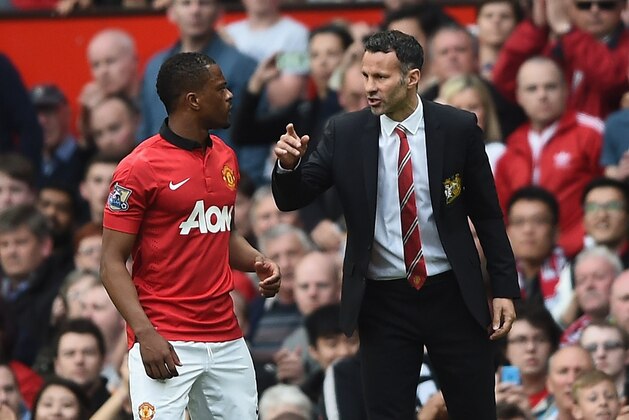 MANCHESTER, ENGLAND - APRIL 26: Ryan Giggs of Manchester United speaks with Patrice Evra during the Barclays Premier League match between Manchester United and Norwich City at Old Trafford on April 26, 2014 in Manchester, England.  (Photo by Laurence Griffiths/Getty Images)