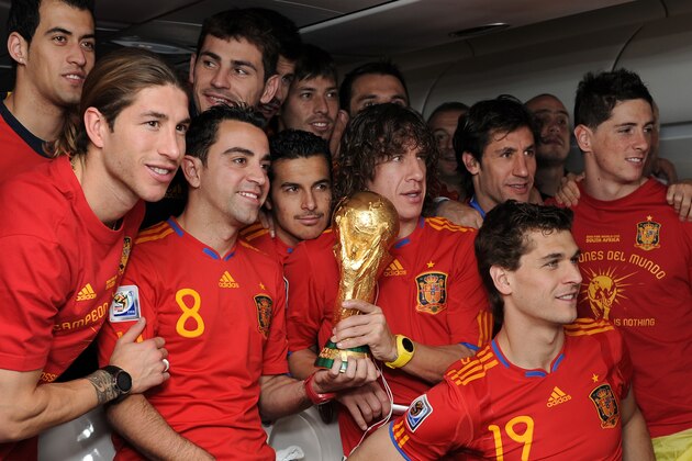 UNSPECIFIED - JULY 12:  (L-R) Sergio Ramos, Xavi Hernandez, Pedro Rodriguez, Carles Puyol, Fernando Llorente and Fernando Torres celebrate with the World Cup trophy during the Spanish team's flight home on board a plane from Johannesburg to Madrid following their victory in the 2010 FIFA World Cup on July 12, 2010 in flight, Unspecified.  (Photo by Jasper Juinen/Getty Images)