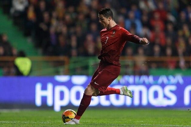 Portugal's Cristiano Ronaldo shoots to score the opening goal during their friendly soccer match with Cameroon Wednesday, March 5 2014, in Leiria, Portugal. It was Ronaldo's 48th goal with Portugal making him the national team's best scorer ever. (AP Photo/Armando Franca)
