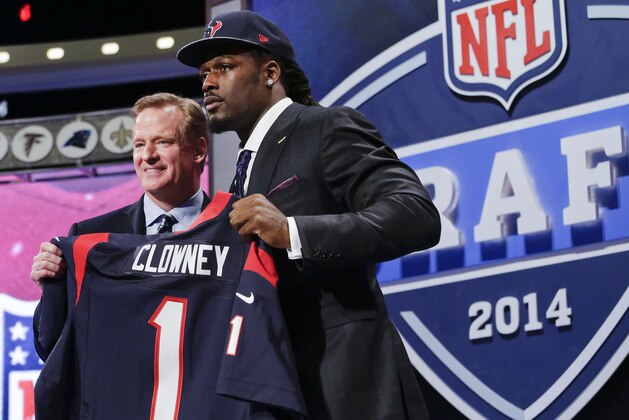 Jadeveon Clowney, defensive end de Carolina del Sur, sostiene un jersey de los Texans de Houston luego de ser la primera selección del draft de la NFL. A su lado el comisionado de la liga, Roger Goodell, el jueves 8 de mayo de 2014. (Foto AP/Craig Ruttle)
