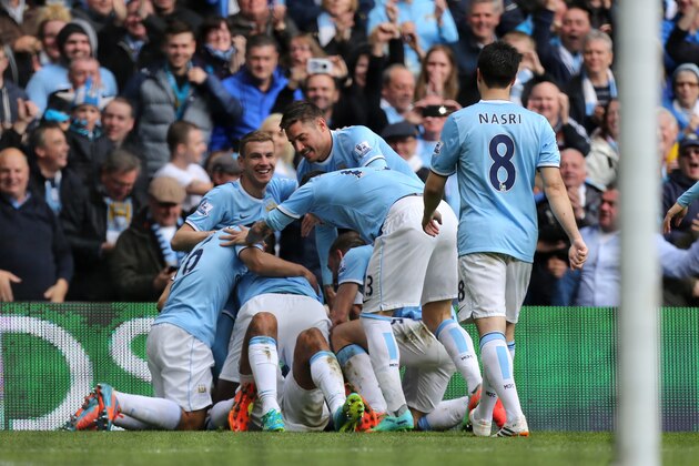 Manchester City players celebrate with their teammate Vincent Kompany, obscured, after he scored their second goal during the English Premier League soccer match between Manchester City and West Ham at the Etihad Stadium in Manchester, England, Sunday May 11, 2014.  (AP Photo/Jon Super)