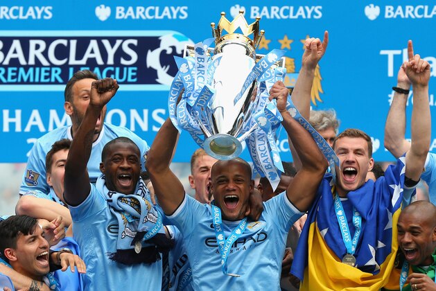 MANCHESTER, ENGLAND - MAY 11:  Vincent Kompany of Manchester City lifts the Premier League trophy at the end of the Barclays Premier League match between Manchester City and West Ham United at the Etihad Stadium on May 11, 2014 in Manchester, England.  (Photo by Alex Livesey/Getty Images)