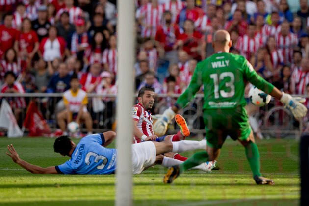 MADRID, SPAIN - MAY 11: David Villa (2ndL) of Atletico de Madrid strikes the ball against goalkeeper Willy Caballero (R) of Malaga CF and his teammate Weligton Robson (L) during the La Liga match between Club Atletico de Madrid and Malaga CF at Vicente Calderon Stadium on May 11, 2014 in Madrid, Spain.  (Photo by Gonzalo Arroyo Moreno/Getty Images)