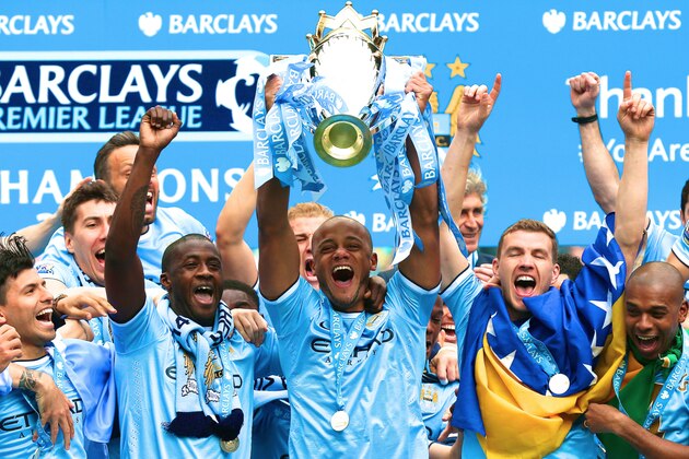 Manchester City's manager Manuel Pellegrini poses for photographers with the trophy after the English Premier League soccer match between Manchester City and West Ham at the Etihad Stadium in Manchester, England, Sunday May 11, 2014.  Manchester City won the Premier League for the second time in three seasons on Sunday, completing its campaign with a comfortable 2-0 victory over West Ham that lacked any of the drama of its previous title.  (AP Photo/Jon Super)