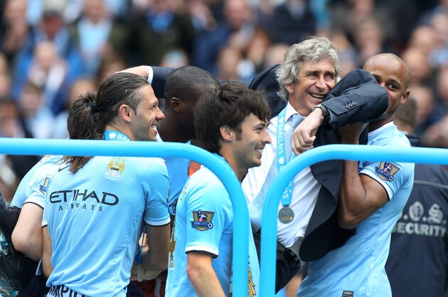 Manchester City's manager Manuel Pellegrini is carried by his players after the English Premier League soccer match between Manchester City and West Ham at the Etihad Stadium in Manchester, England, Sunday May 11, 2014.  Manchester City won the Premier League for the second time in three seasons on Sunday, completing its campaign with a comfortable 2-0 victory over West Ham that lacked any of the drama of its previous title.  (AP Photo/Jon Super)