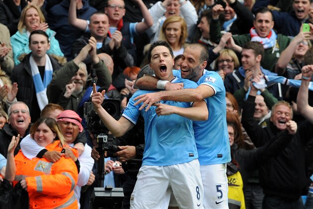 Manchester City's Samir Nasri, left, celebrates with teammate Pablo Zabaleta after scoring against West Ham during the English Premier League soccer match between Manchester City and West Ham United at the Etihad Stadium,  Manchester, England, Sunday, May 11, 2014. (AP Photo/Rui Vieira)